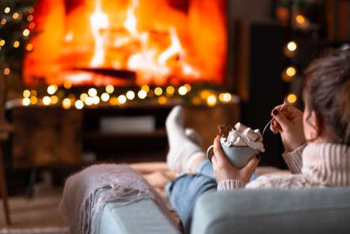 Female relaxing on a sofa holding a mug on Christmas 2