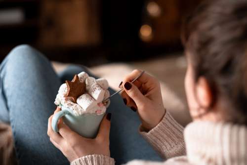 Female relaxing on a sofa holding a mug on christmas closeup