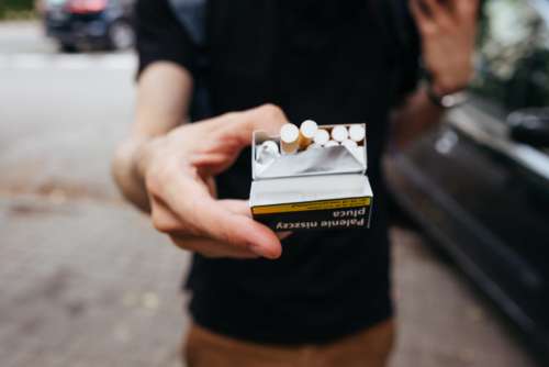 A male offering a cigarette