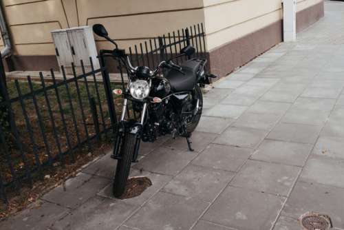 Black motorcycle parked on a sidewalk