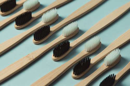 Wooden Toothbrushes Lined Up Against A Green Background Photo