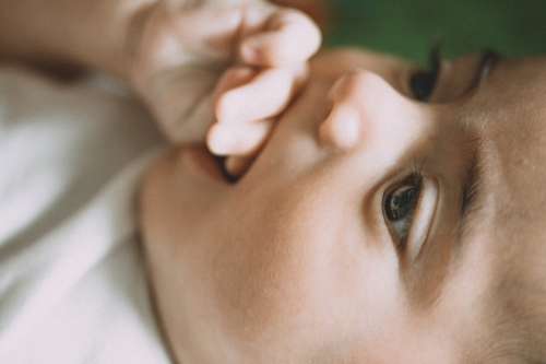 Profile Of Baby Holding Their Hand In Mouth Photo