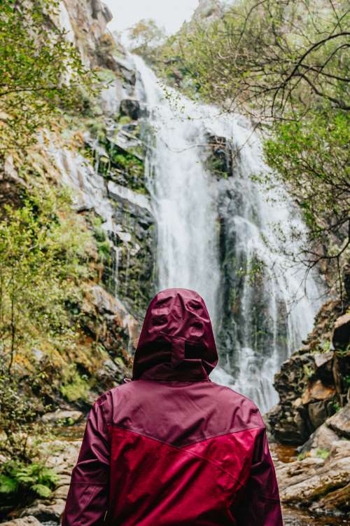 Person In Red Raincoat Admires A Huge Waterfall Photo