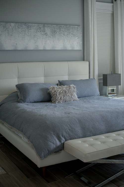 Photo Of A Bed With A White Bed Frame And Blue Sheets Photo