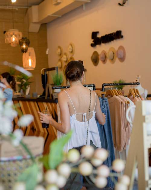 Person Browses Clothing Racks In A Store Photo