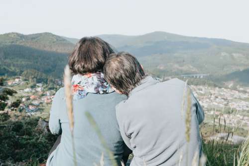 Two People Away From Camera Enjoying A Distant View Photo