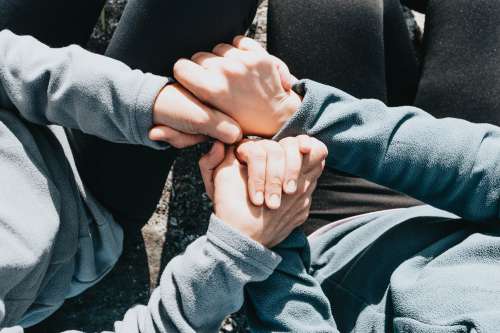 Looking Down Toward People Holding Hands And Sitting Photo