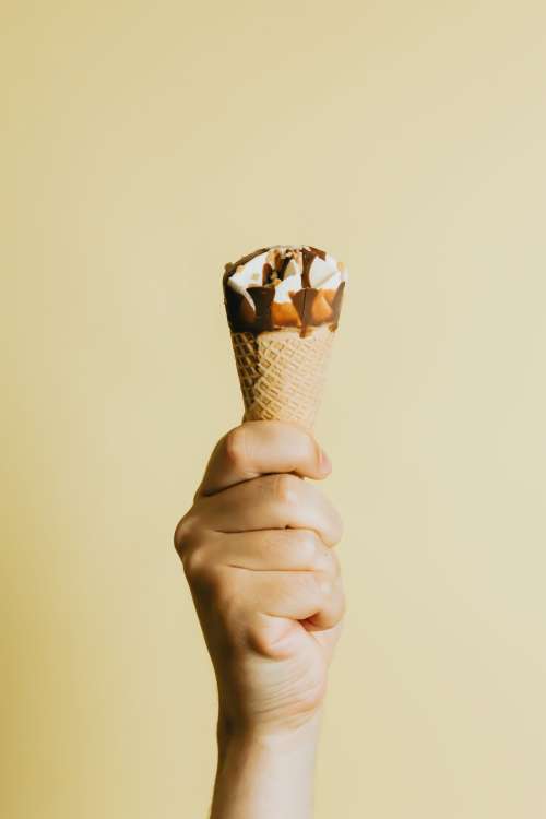 Hand Grips A Chocolate Dripped Ice Cream Cone Photo