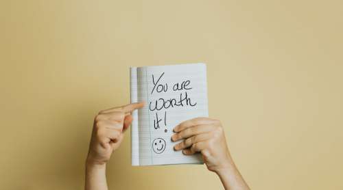 Hand Holds A Book Up With Lined Paper And And Written Text Photo