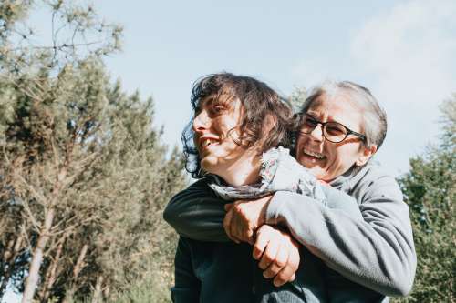 Senior Woman In Glasses Hugs A Woman From Behind Photo