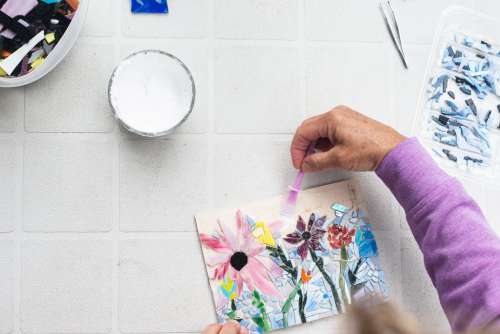 Flatlay Of A Person Adding Glue To A Glass Mosaic Photo