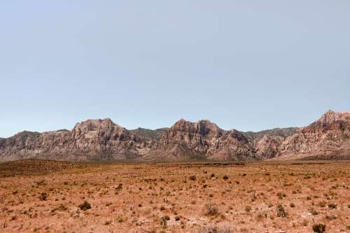 Landscape Of Brown Grass With Rocky Mountains Photo