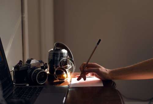 Hand Holds A Pencil Ready To Write At A Desk Photo