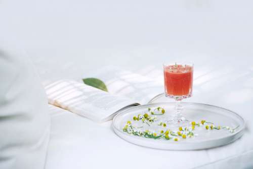 Drink On A Plate With A Book Behind It Photo