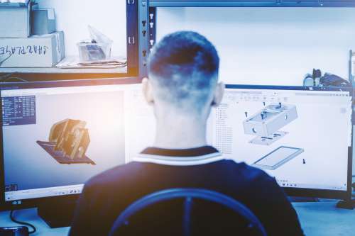 Engineer Designing 3D Models on Dual Monitors in Modern Workspace