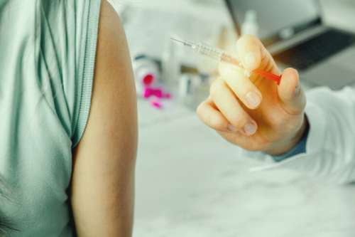 Doctor giving injection vaccine to patient arm